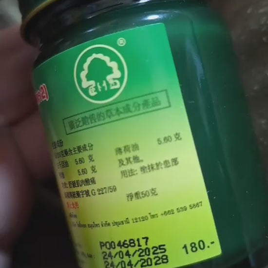 Phoyok balm jar opened showing green herbal content