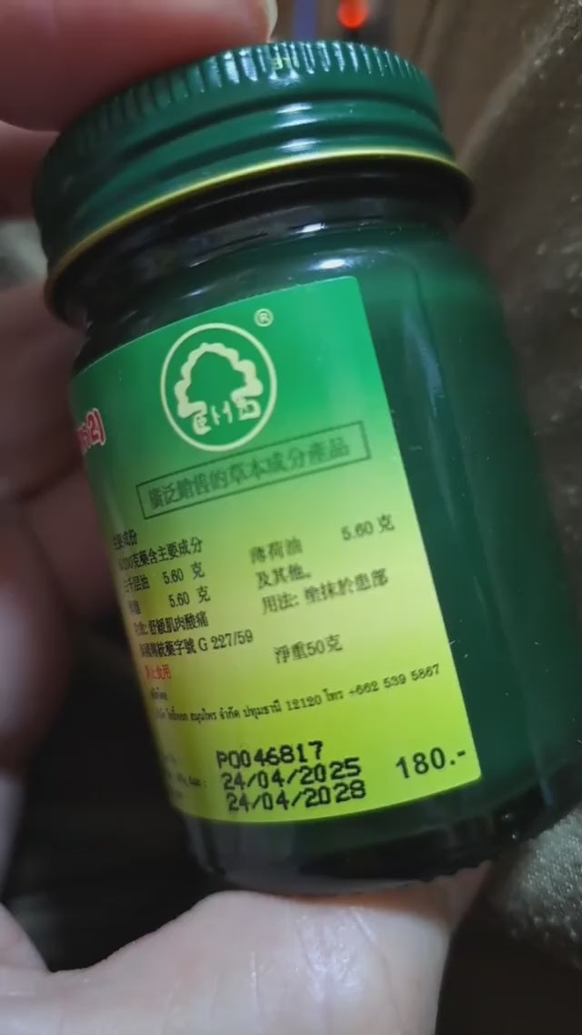 Phoyok balm jar opened showing green herbal content