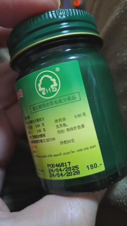 Phoyok balm jar opened showing green herbal content