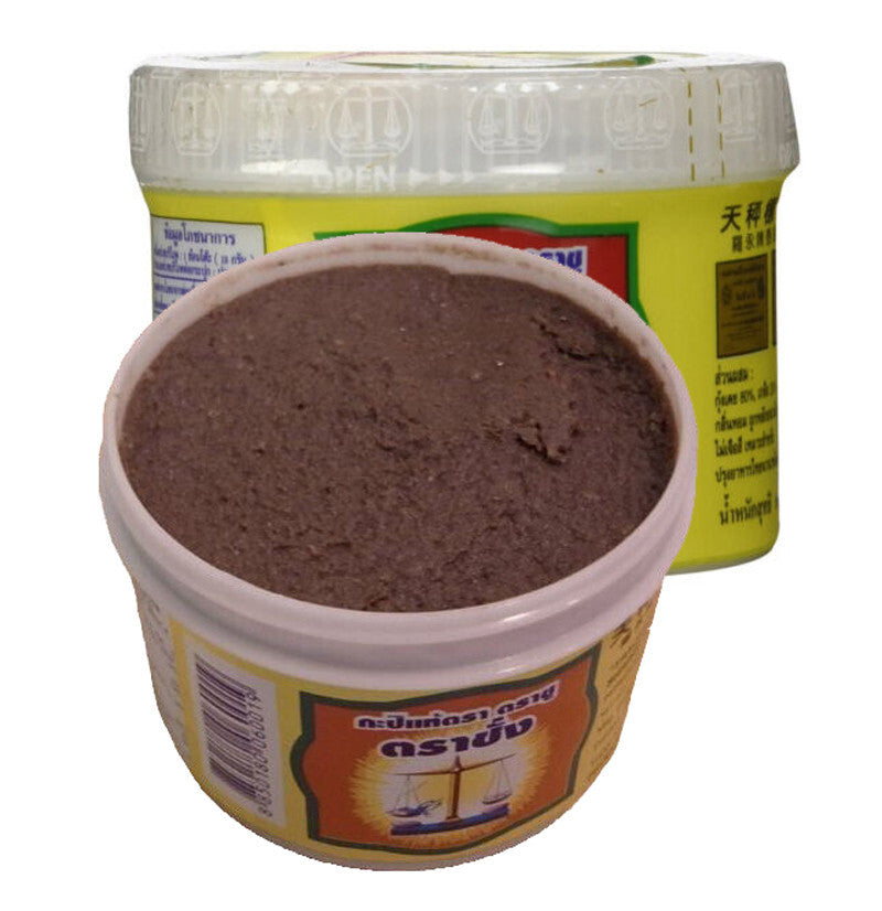 An image showing the Trachang shrimp paste jar with its lid removed, revealing the dark brown, textured paste inside.
