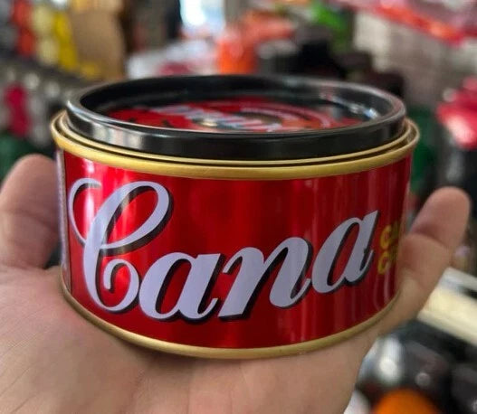 Person holding Cana Car Cream Wax red container, side label detail shown