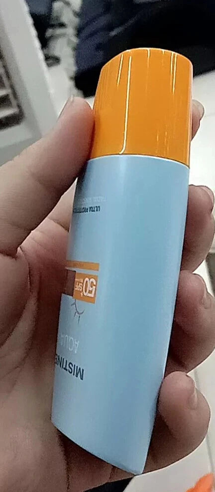 Mistine Aqua Sunscreen Ultra Protection Matte Light Facial SPF50 40ml in a person's hand, showcasing its light blue design.