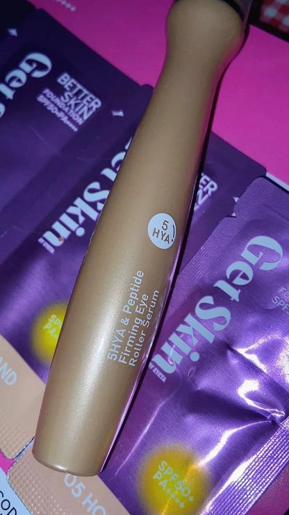 Real product photo of Baby Bright Eye Roller tube placed against its purple packaging.