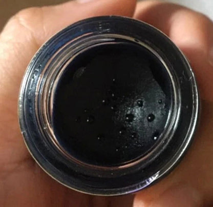 Black Phomthong Hair Growth Facial Herb Cream in a jar, featuring a dark texture, ideal for beard and mustache growth.