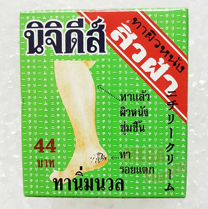 Front of the green and red NICHIDI Cracked Skin Cream box showing Thai text and image of a leg