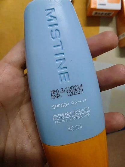 Mistine Aqua Sunscreen SPF50 PA++++ bottle held in hand showing product texture