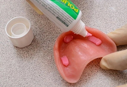 Polident Denture Adhesive Cream applied to denture demonstrating secure adhesive use