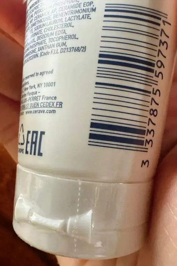 A close-up view of the back of a CeraVe Moisturising Cream tube focusing on the barcode and ingredient text.