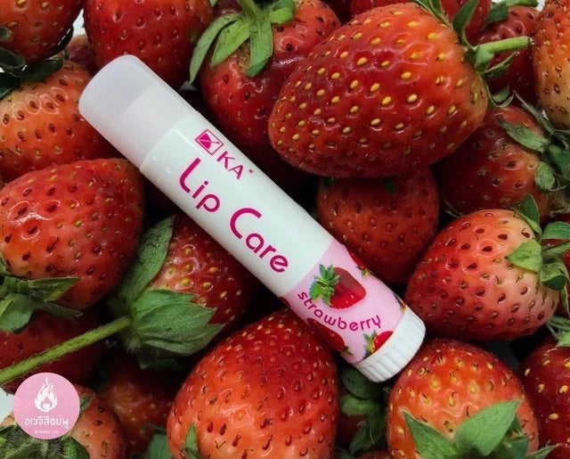 KA Lip Care Plus Strawberry lip balm tube placed on fresh strawberries