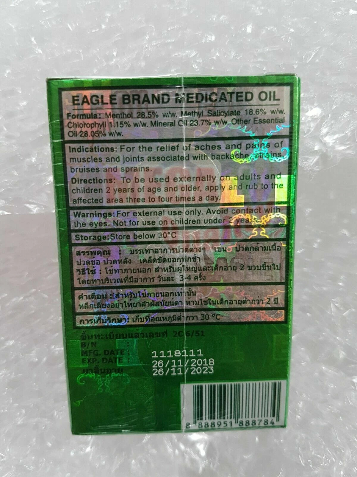 Eagle Brand Medicated Oil back label, ingredients, usage instructions, and storage information on green packaging.