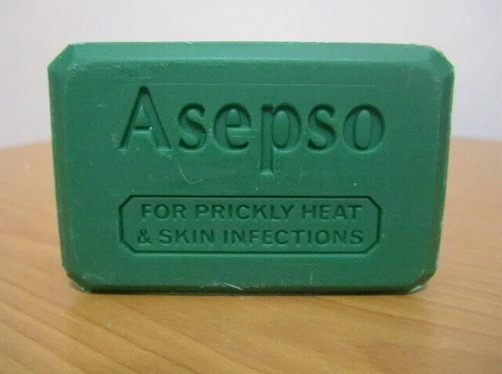 Asepo green soap bar on a wooden surface, showing the embossed text "Asepso FOR PRICKLY HEAT & SKIN INFECTIONS."