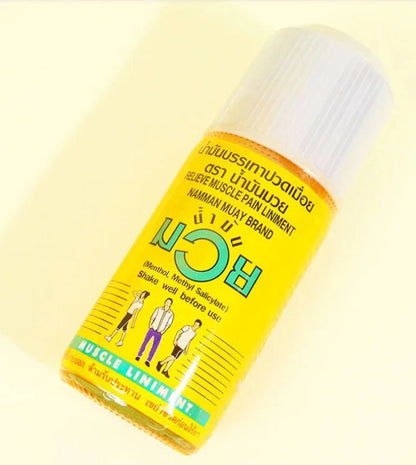 Namman Muay Liniment Oil 120cc angled bottle on yellow background showing lightweight emulsion texture for easy massage absorption