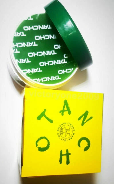 Tancho Hair Pomade green jar and yellow box angled view