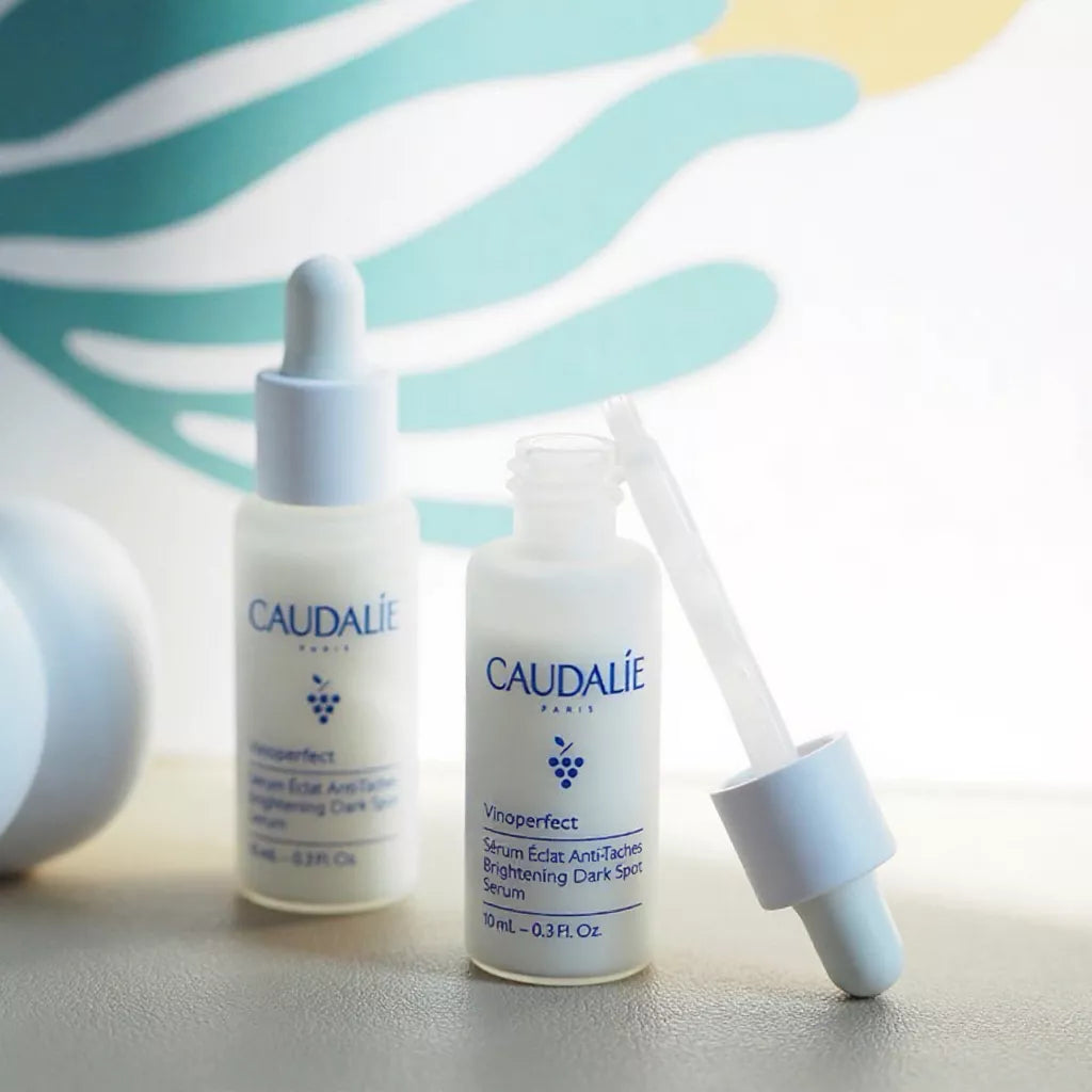 Caudalie Vinoperfect Serum mini skincare set arranged on soft pastel background