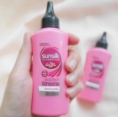 Woman holding two Sunsilk Leave On Treatment bottles showing smooth and manageable hair care product