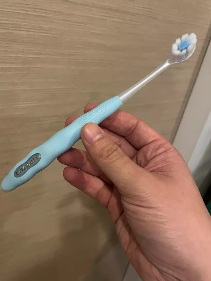 Colgate Cushion Clean Toothbrush blue handle side profile highlighting slim head and ergonomic grip