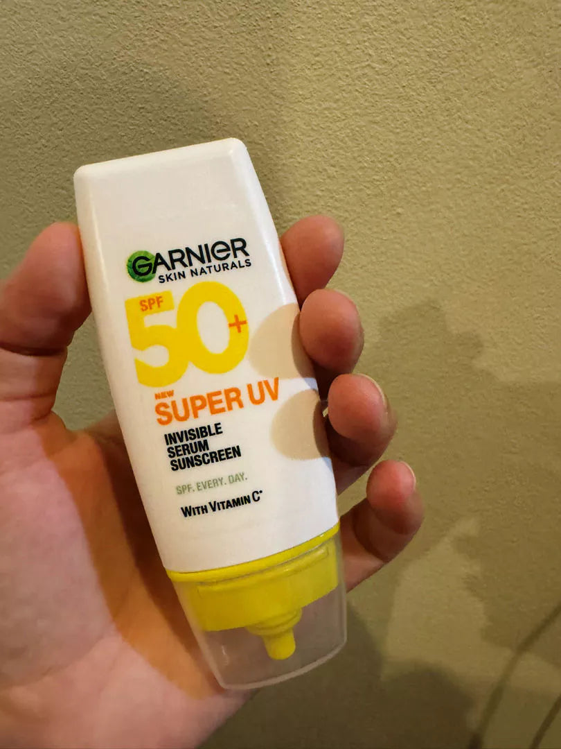 Garnier Super UV Serum SPF50 PA++++ tube held in hand front view