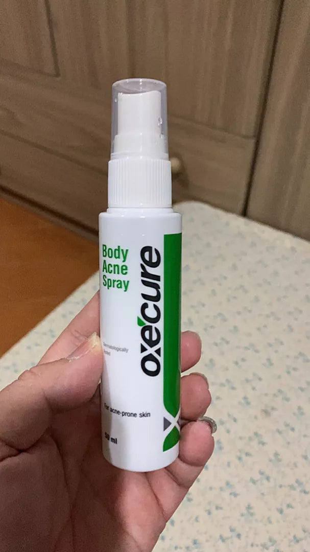 Oxe Cure Body Acne Spray bottle held in hand for daily acne care routine