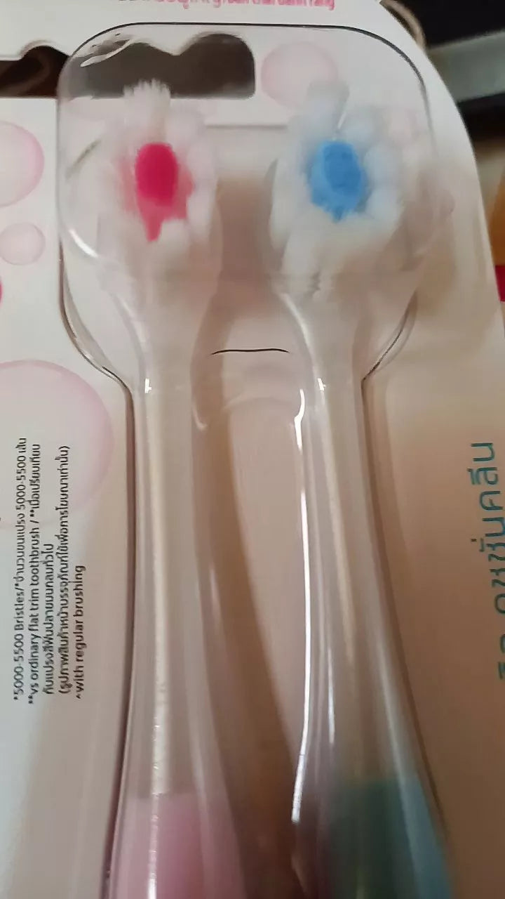 Colgate Cushion Clean Toothbrush close up of two brush heads with fluffy soft bristles pink and blue