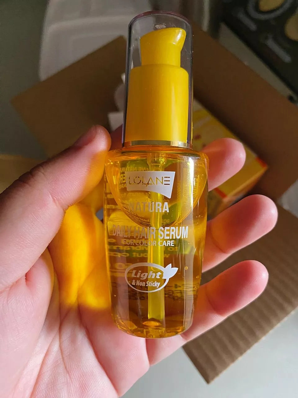Lolane Natura Color Hair Serum Daily Magic In One Sunflower Oil 50ml bottle held in hand, designed for color treated hair care.