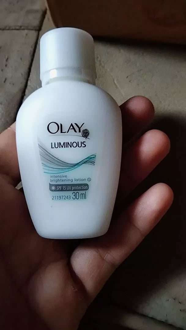 Olay Luminous Intensive Lotion SPF15 30ml in hand, offering UV protection and hydration for radiant skin.
