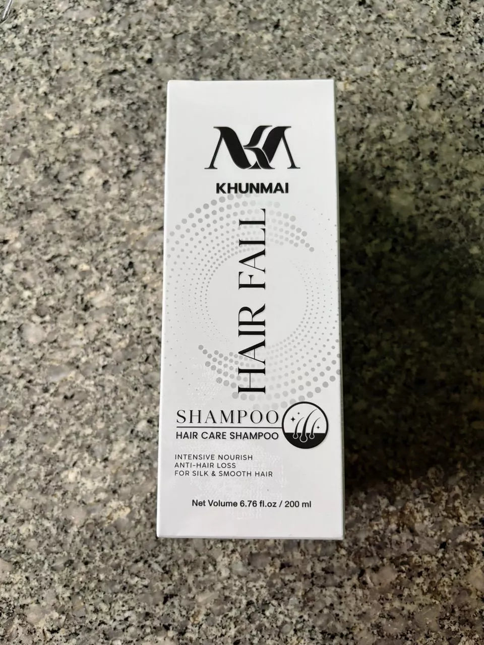 KHUNMAI Hair Fall Shampoo box standing upright on concrete surface