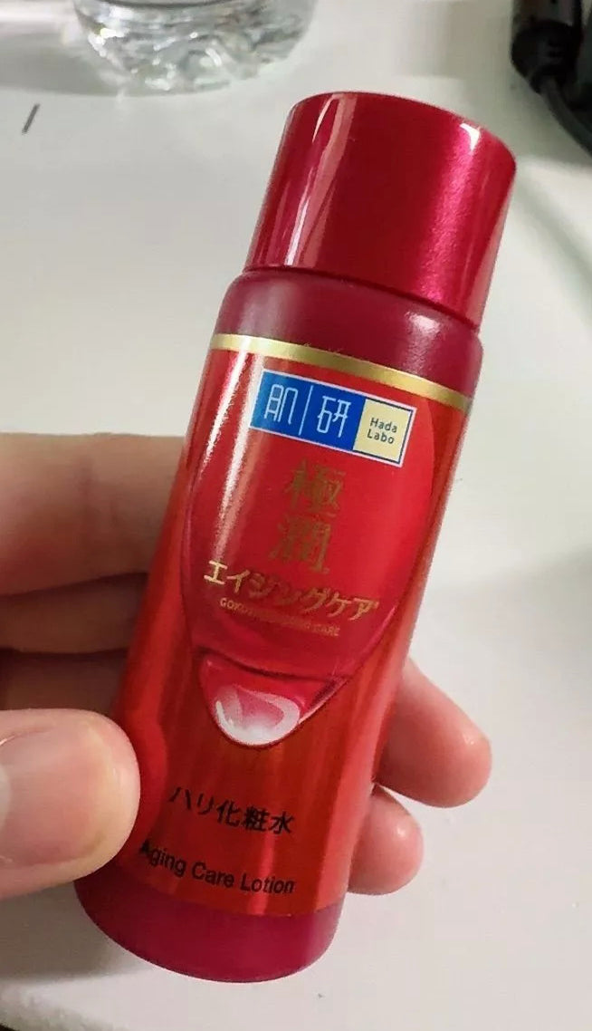 Hada Labo 3D Retinol Lotion 30ml red bottle held in hand close up