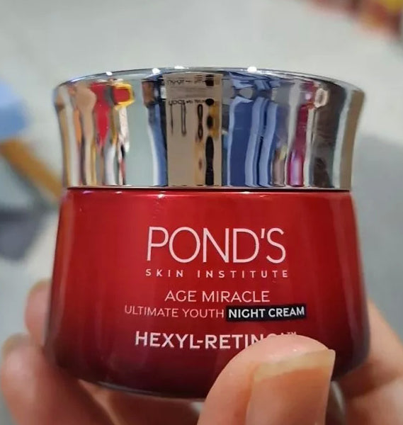 Pond 's Age Miracle Night Cream jar in hand close up with silver cap