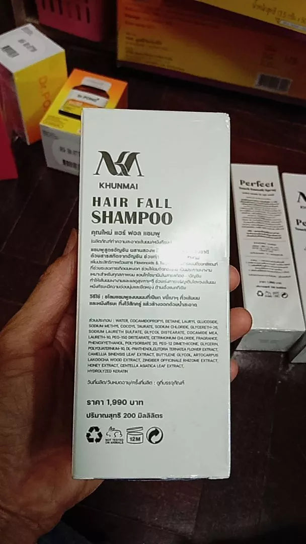 KHUNMAI Hair Fall Shampoo product box and bottle shown together in hand