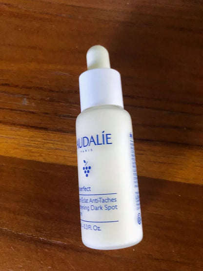 Caudalie Vinoperfect Serum 10ml bottle standing on wooden surface
