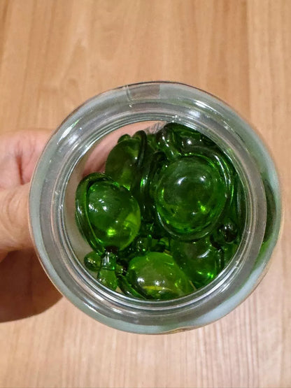 Top view of green capsules inside Lesasha Hair Vitamin Serum Capsule Olive Oil jar
