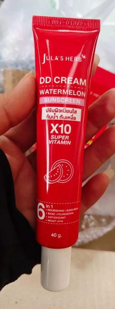 Close-up handheld view of Jula Herb DD Cream Watermelon tube with red packaging