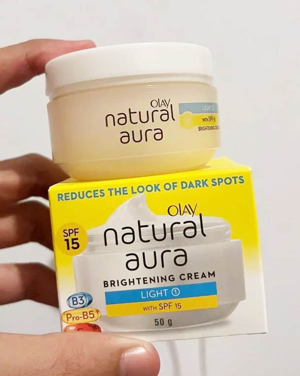 Olay Natural Aura Cream jar placed on top of its yellow packaging box