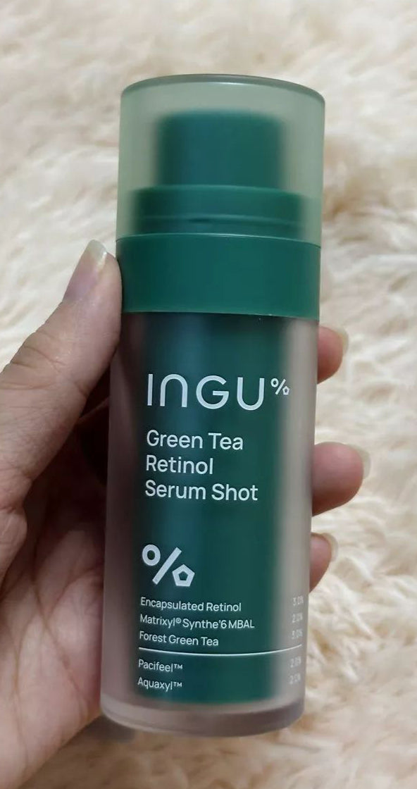 Close-up hand photo featuring INGU Retinol Serum Shot bottle with clear label and design