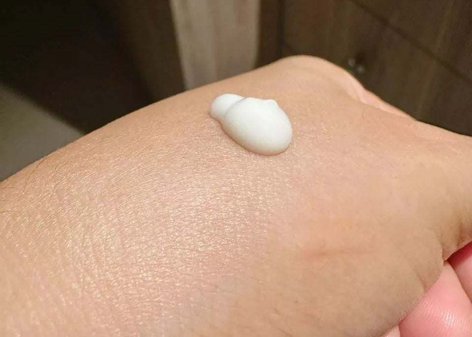 INGU Vitamin C AOX brightening serum swatch on hand displaying creamy texture