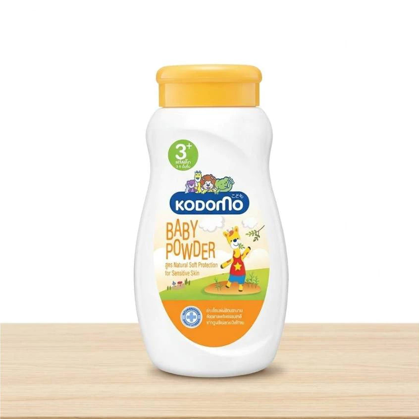 Kodomo Baby Powder 3+ orange bottle on a wooden shelf, white background.